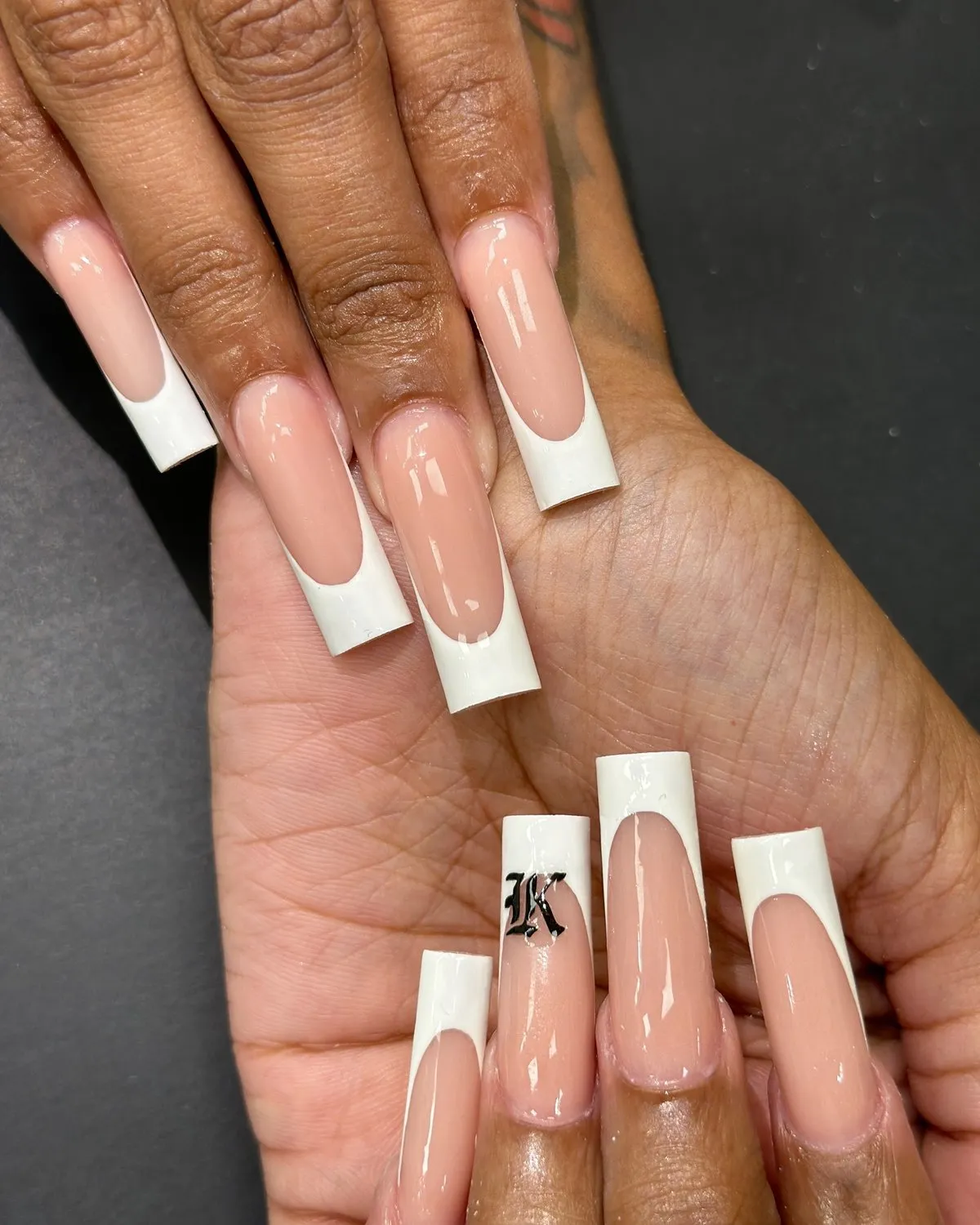Long square nails with a classic white French tip and one initial accent.