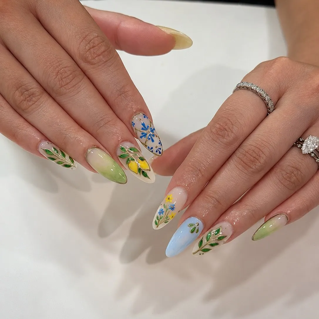 Almond nails with hand-painted lemons, blue florals and olive leaves.