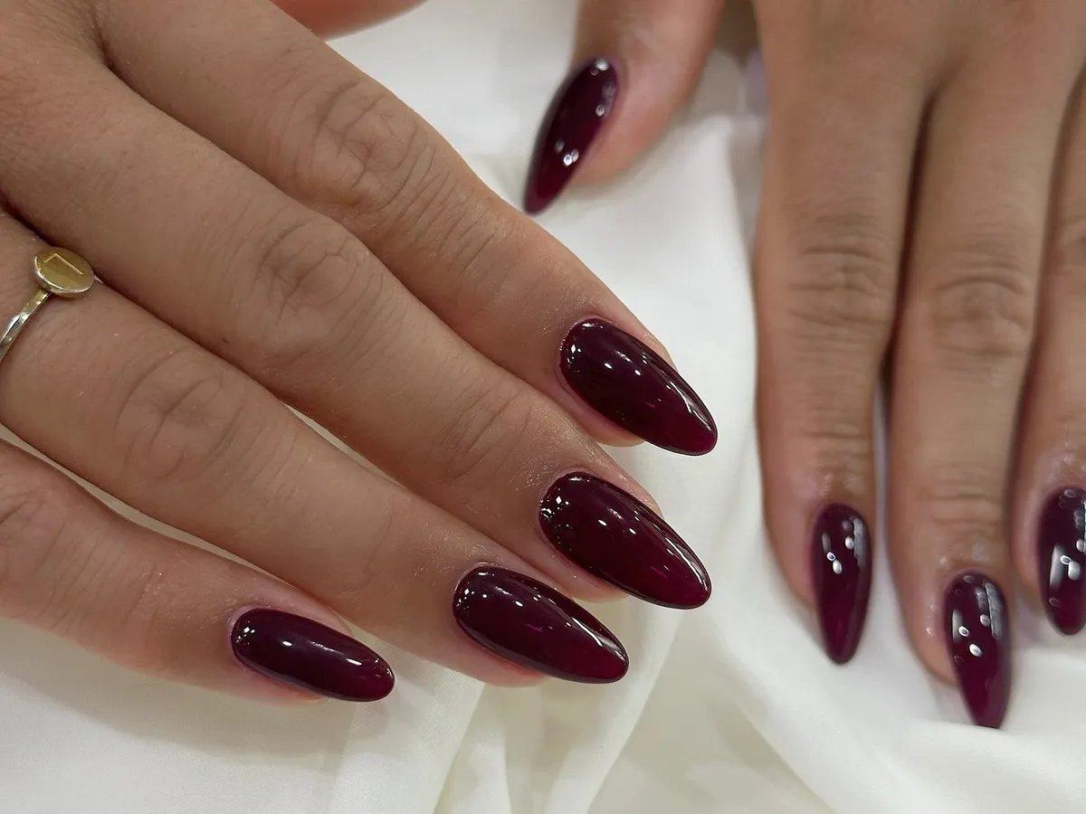 Glossy deep burgundy Shellac on natural-length almond nails.