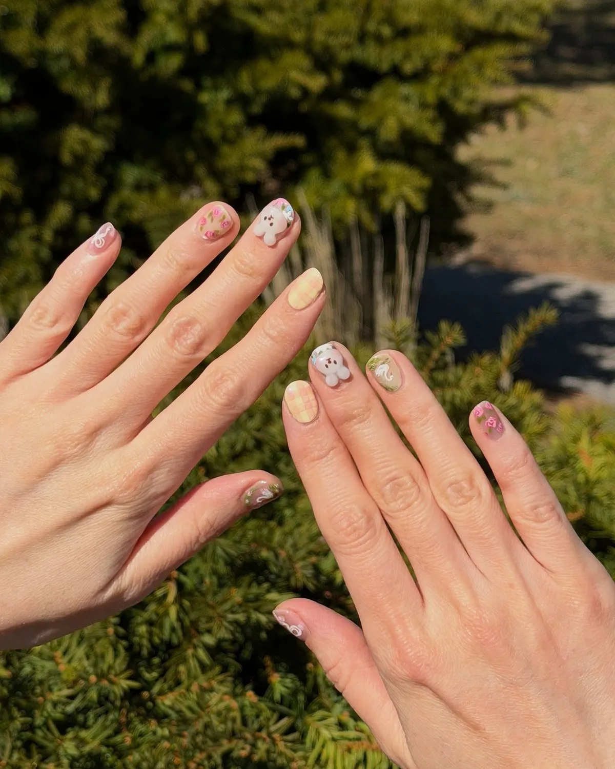 Short natural nails in soft pastels with small hand-painted accents.