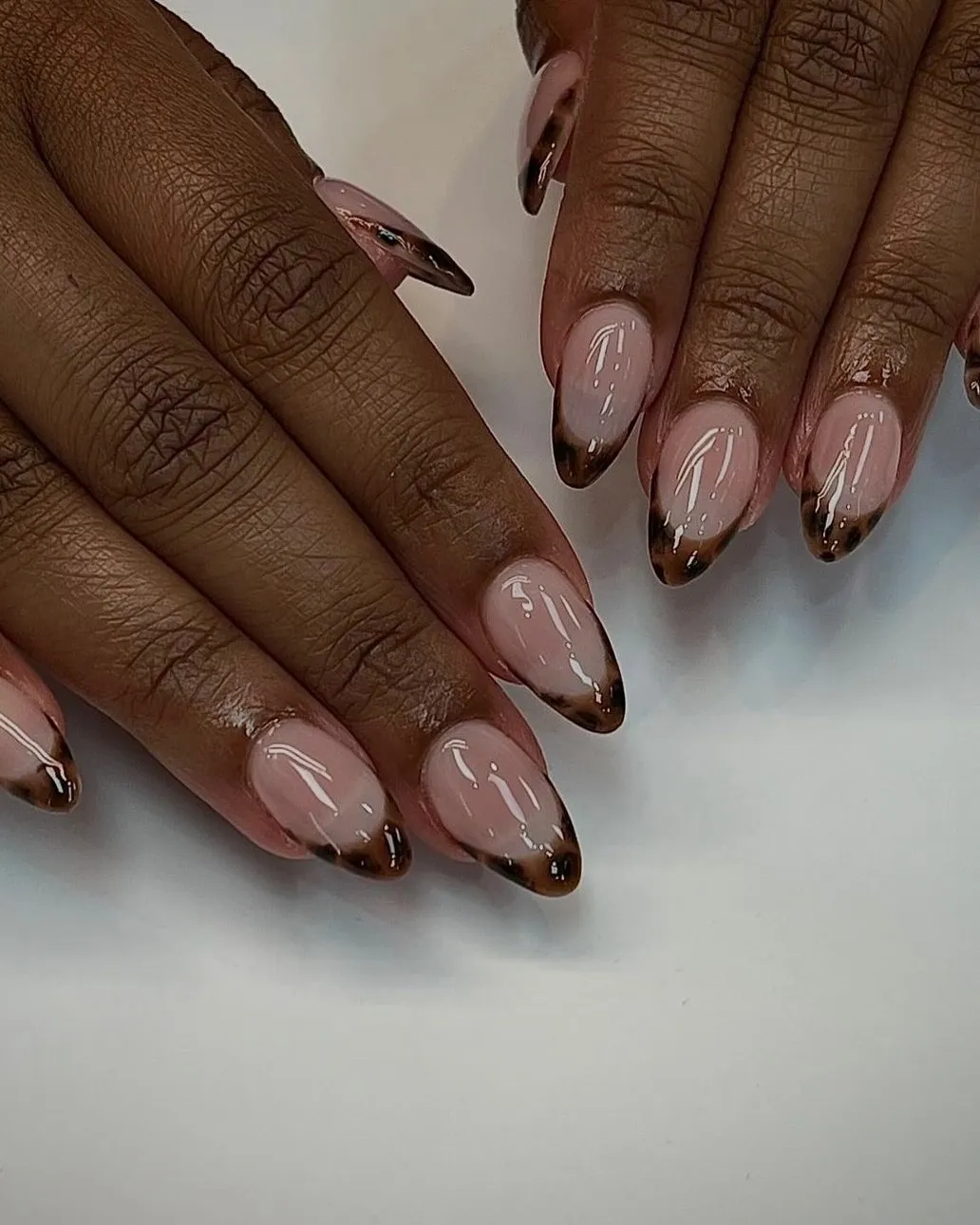 Natural almond nails with a thin tortoiseshell French tip.